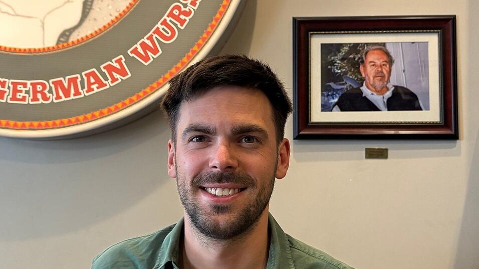 Fabian F&ouml;rster steht vor einem Foto seines Gro&szlig;vaters, nach dem &laquo;Dieters Grill&raquo; benannt wurde.