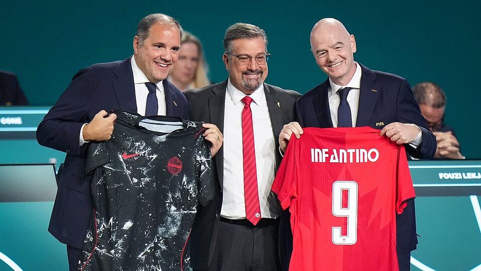 FIFA-Pr&auml;sident Gianni Infantino (r) pr&auml;sentiert mit Vizepr&auml;sident Victor Montagliani (l) und Kanadas Fu&szlig;ballchef Peter Augruso ein kanadisches Nationaltrikot mit seinem Namen.