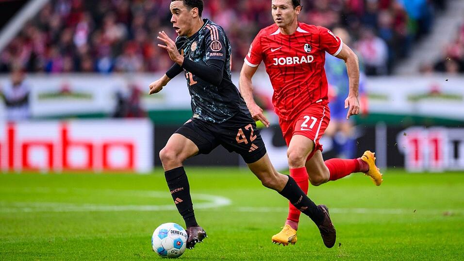 Bayern-Star Jamal Musiala enteilt Freiburgs Nicolas Höfler.