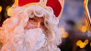 Stefan Dößereck, Nikolaus- und Weihnachtsmanndarsteller, trägt eine FFP2-Maske auf dem Weihnachtsmarkt 'Nikolausdorf' auf dem Rudolfplatz. Stefan Dößereck, Nikolaus- und Weihnachtsmanndarsteller, trägt eine FFP2-Maske auf dem Weihnachtsmarkt 'Nikolausdorf' auf dem Rudolfplatz.