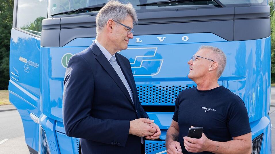 Lkw-Fahrerinnen und Lkw-Fahrer sollen laut Minister Schnieder (links) profitieren.