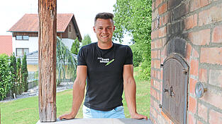 Michael Englberger im Garten seines Elternhauses in Niederpiebing. Er ist nicht nur fotogen, sondern auch handwerklich begabt: Den Ofen hat er selbst gebaut, um Pizza zu backen.