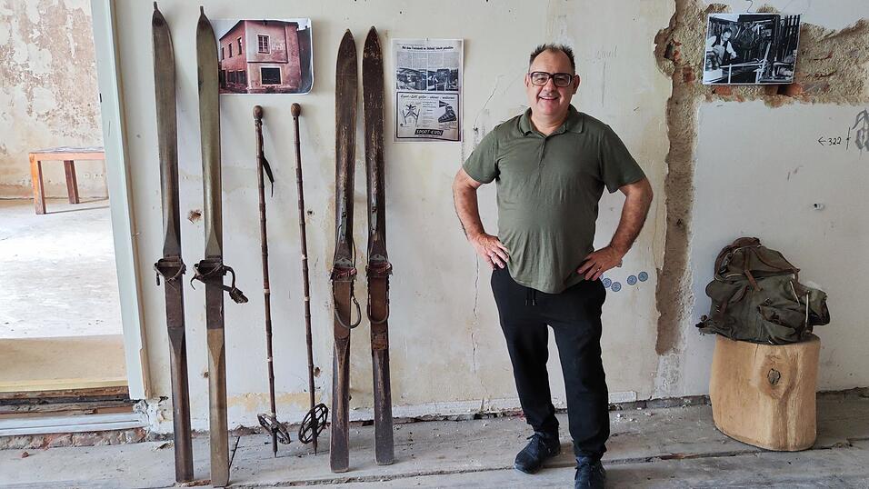 Martin Erdl im zuk&uuml;nftigen Museum neben seinen &auml;ltesten St&uuml;cken: Ski aus der Zeit um 1925.