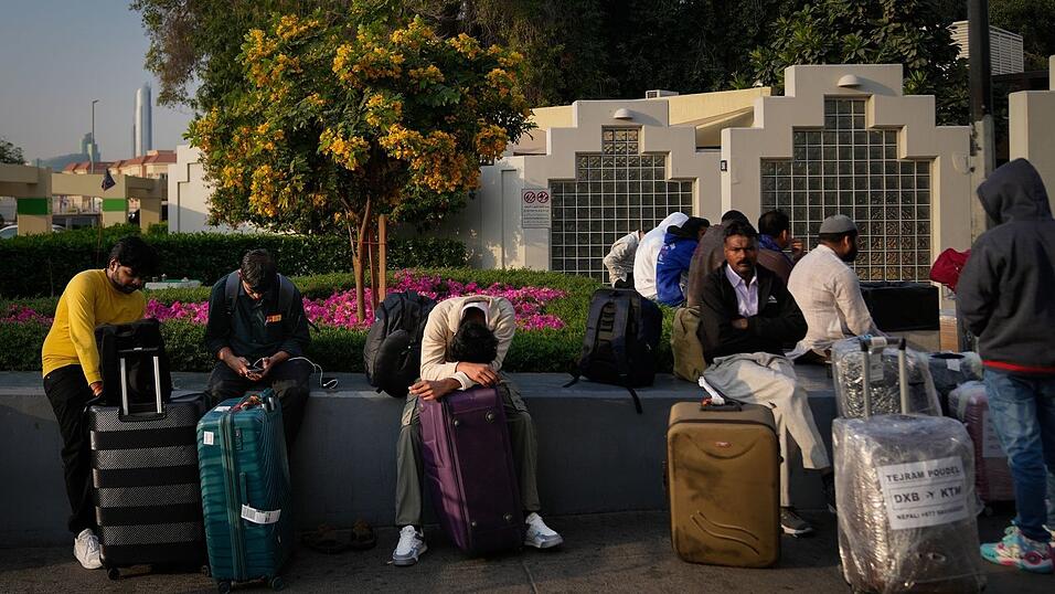 Gestrandete Passagiere warten auf dem Flughafenparkplatz in Dubai.