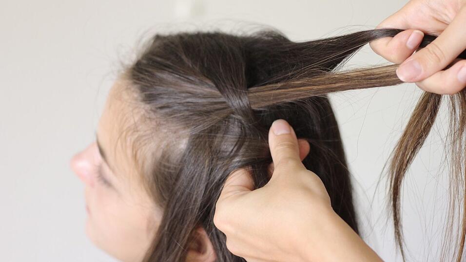 Zu der hinteren Strähne kommt bei jeder Flechtung eine neue Haarsträhne zu dem aktuellen Strang dazu, ehe weitergeflochten wird. Zu der hinteren Strähne kommt bei jeder Flechtung eine neue Haarsträhne zu dem aktuellen Strang dazu, ehe weitergeflochten wird.