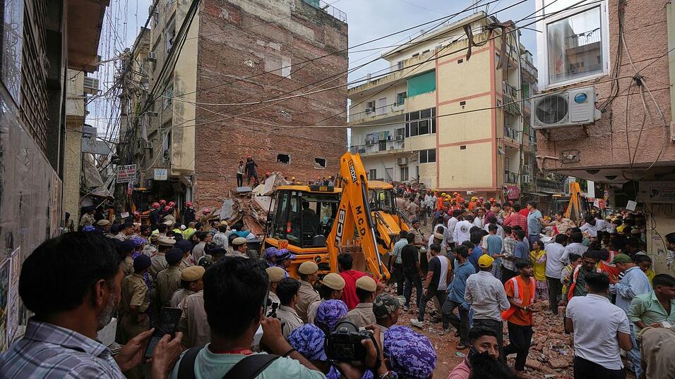 Rettungskr&auml;fte suchen in Neu-Delhi unter den Tr&uuml;mmern eines eingest&uuml;rzten Geb&auml;udes nach &Uuml;berlebenden.