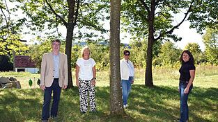 Am Baum in der Mitte des Bucher Friedhofs soll der Platz f&uuml;r Sternenkinder entstehen. Daf&uuml;r engagieren sich (v.l.) Pfarrer Konrad Eder, Pfarrgemeinderatsvorsitzende Rachel Sasowski sowie die Pfarrgemeinderatsmitglieder und Initiatorin Martina Senser und Landschaftsarchitektin Gabriele Salzberger.