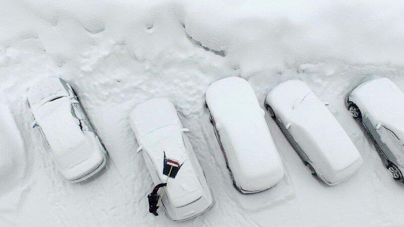 Ausgrabungen: Ein Mann befreit in Ramsau am Dachstein sein Auto von Schnee. Ausgrabungen: Ein Mann befreit in Ramsau am Dachstein sein Auto von Schnee.