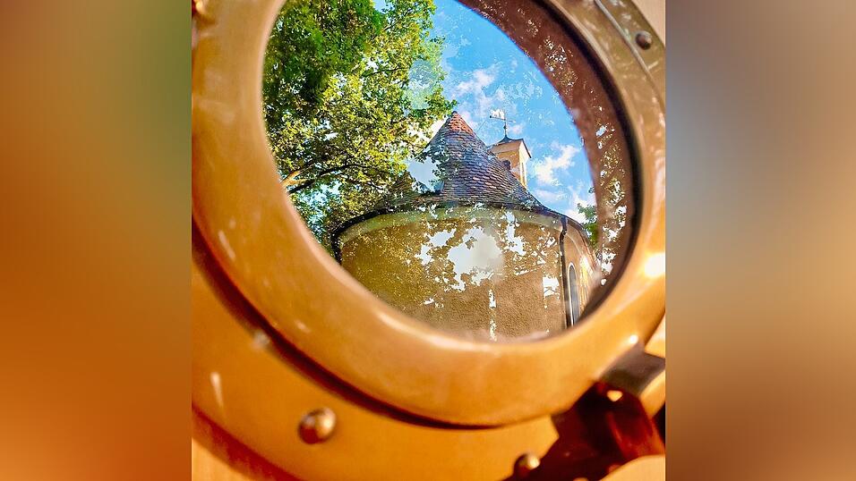 Die Leonhardikirche wird von einem Bullauge des katholischen „Boot des Lebens“ reflektiert. Die Leonhardikirche wird von einem Bullauge des katholischen „Boot des Lebens“ reflektiert.