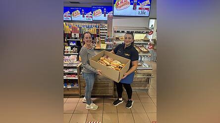 Elissavet Pechlivanidi Teamleitung (r.) übergibt Gebäck an eine Mitarbeiterin von Foodsharing.