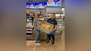 Elissavet Pechlivanidi Teamleitung (r.) übergibt Gebäck an eine Mitarbeiterin von Foodsharing.