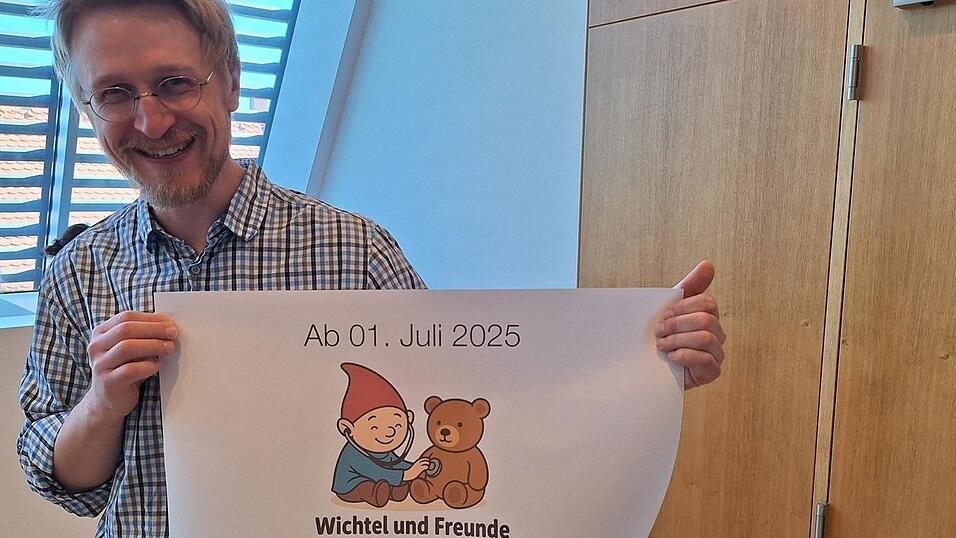 Kinderarzt Dr. Ilia Nikitin mit dem Logo seiner Praxis.
