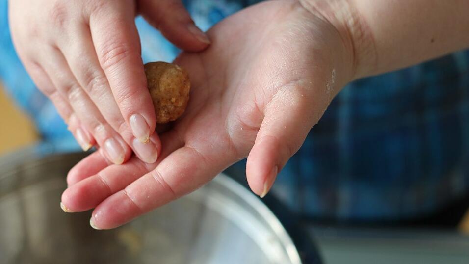 Aus der Masse kleine Kugeln formen und auf Stäbchen stecken. Aus der Masse kleine Kugeln formen und auf Stäbchen stecken.