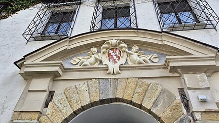 Das Schlossportal mit dem Ortenburgwappen und zwei Amoretten
