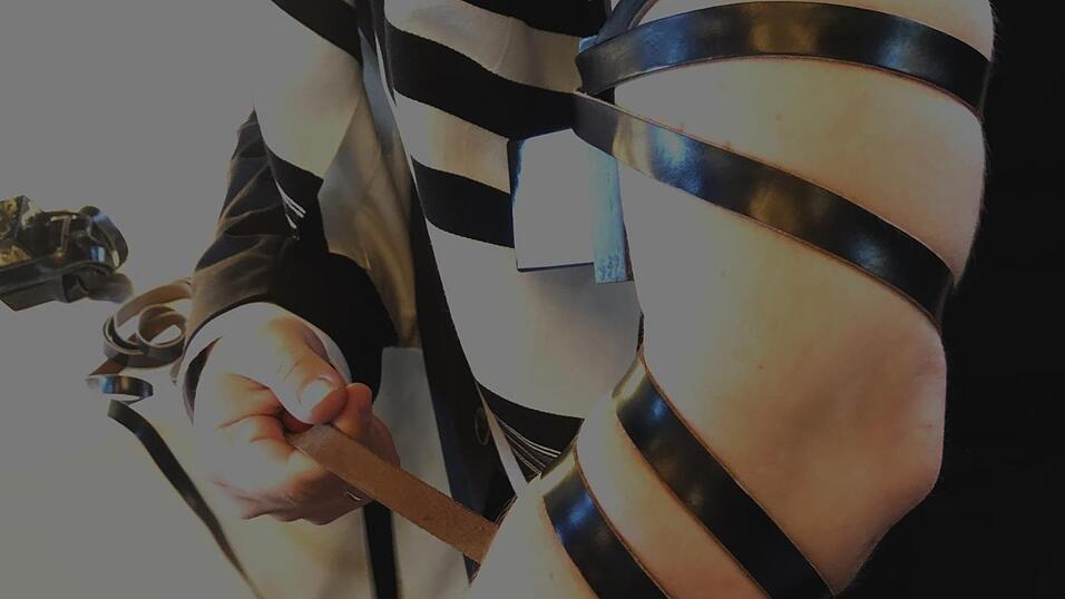 Rabbiner Mendel Muraiti bindet sich den Tefillin - den Gebetsriemen - auf seinen linken Arm.