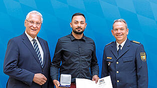 Burak Furtner (Mitte) ist nun Träger der Courage-Medaille. Für sein Eingreifen dankten ihm am Montag Bayerns Innenminister Joachim Herrmann (links) und Landespolizeipräsident Michael Schwald (rechts).