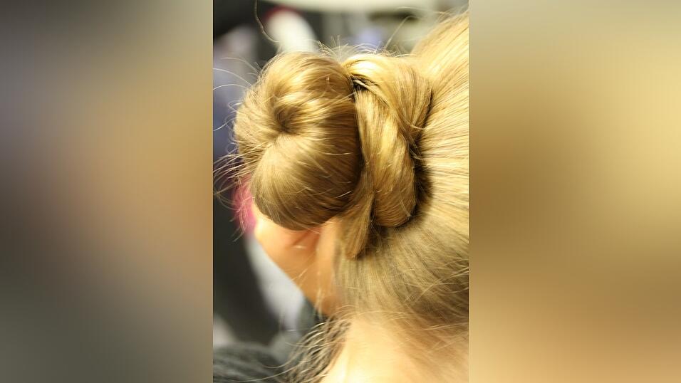 4. Die restlichen Haare legt sie um den Dutt herum und befestigt sie mit Haarnadeln.