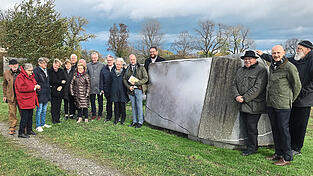 Das Kunstwerk „Professorenstein Gut Eglsee“ an einem Feldweg südlich von Gut Eglsee erinnert an einen Vorfahren der Familie Beckmann. Im Rahmen der Nachhaltigkeitswerkstatt wurde es bei stürmischem Westwind den Teilnehmern vorgestellt (v.l.): Künstler Marcel Manche, Martja Manche, Edmund Langer, Prof. Dr. Anja Faße, Barbara Unger, Dr. Bernhard Widmann, Dr. Regine Langer-Huber, Bürgermeister Werner Schäfer, Oberbürgermeister Markus Pannermayr, MdL Josef Zellmeier, Prof. Dr. Ursula Münch, Prof. Dr. Carl Christian Beckmann, MdL Tobias Beck, Toni Hinterdobler, Prof. Dr. Henning Böckemeier-Beckmann und Erich Gruber.