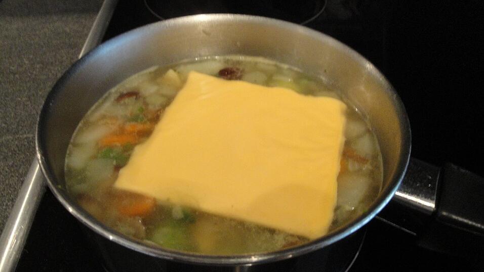 Die Käsescheiben unter Rühren schmelzen lassen und die Suppe heiß genießen.
