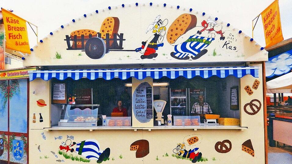 Diese Fassade kennt jedes Kind: Asterix und Obelix mit Käselaiben. In dieser über 15 Jahre alten Aufnahme sieht man links Ulrike Weber und rechts ihren Vater Kurt Wührl. Wie immer befindet sich der Stand beim Festzelt Reisinger.