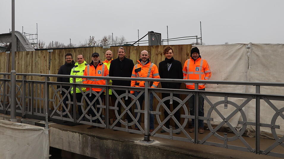 Freuen sich, dass Fu&szlig;g&auml;nger ab jetzt wieder &uuml;ber die Isarbr&uuml;cke gehen k&ouml;nnen: Gesch&auml;ftsf&uuml;hrer Alexander Oswald (l.), Ingenieur Michael Scheerschmidt (4.v.l.), B&uuml;rgermeister Matthias Kohlmayer (4.v.r.), Bauleiter Sebastian Bruckmeier (3.v.r), Bereichsleiter Konstruktiver Ingenieurbau Thomas Ruhland (2.v.r) sowie Vertreter des Staatlichen Bauamts Landshut.&nbsp;