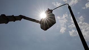 Ein Elektromonteur montiert in Halle eine neue LED-Leuchte für die Straßenbeleuchtung. Ein Elektromonteur montiert in Halle eine neue LED-Leuchte für die Straßenbeleuchtung.