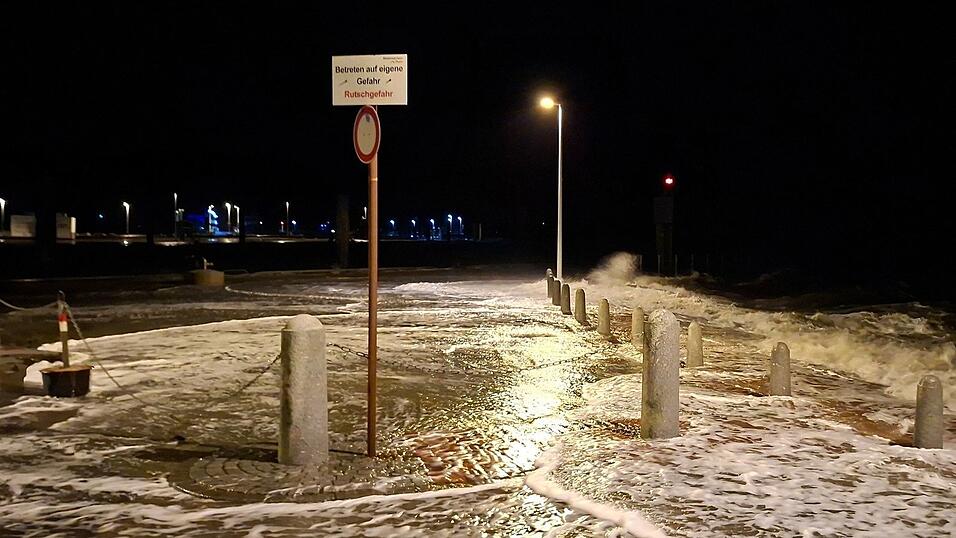 Wellen überspülen die Promenade in Wilhelmshaven.