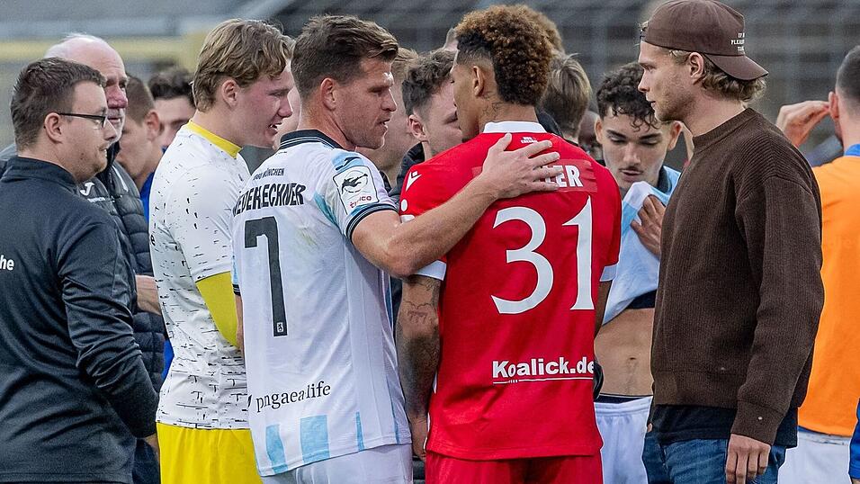Florian Niederlechner (TSV 1860 München) spricht nach dem Rassismus-Vorfall aufmunternd mit Justin Butler (FC Energie Cottbus).
