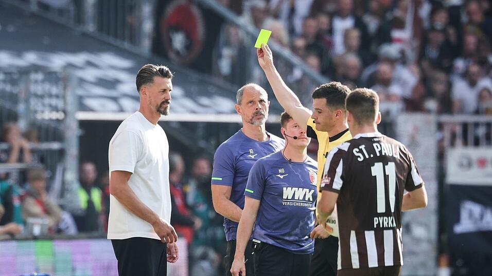 Schiedsrichter Harm Osmers zeigt Trainer Sandro Wagner (FC Augsburg, l) die gelbe Karte. Schiedsrichter Harm Osmers zeigt Trainer Sandro Wagner (FC Augsburg, l) die gelbe Karte.