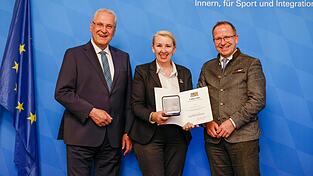 Sportminister Joachim Hermann und BLSV-Pr&auml;sident J&ouml;rg Ammon &uuml;berreichten die Ehrenmedaille an Carolan H&ouml;cherl--Neubauer.