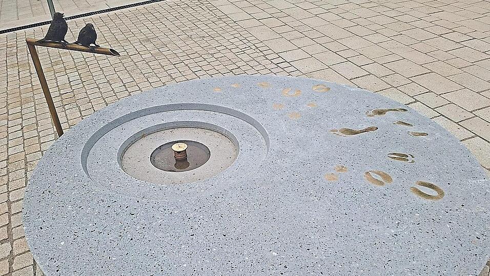 Herzstück ist ein Brunnen - ein runder Betonkorpus mit einem Durchmesser von zwei Metern. Auf dem Wasserzulauf sitzen zwei Vögel aus Messing. Im Internet wird darüber heftig diskutiert. Herzstück ist ein Brunnen - ein runder Betonkorpus mit einem Durchmesser von zwei Metern. Auf dem Wasserzulauf sitzen zwei Vögel aus Messing. Im Internet wird darüber heftig diskutiert.