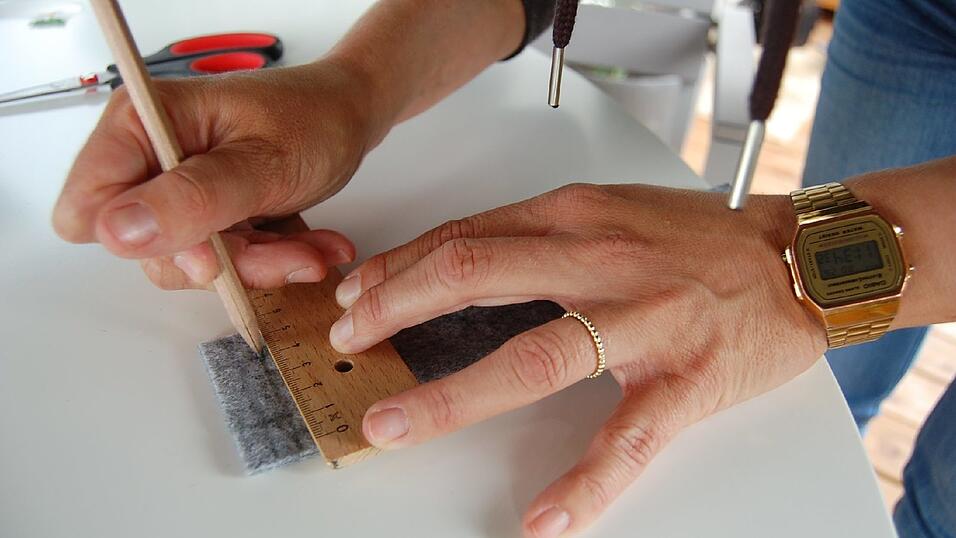 2. Wenn du dich entschieden hast, wie breit dein Armband werden soll, misst du mit dem Lineal Länge und Breite auf dem Filz ab und markierst das Ganze mit dem Bleistift. Dann einfach ausschneiden. Als nächstes musst du ausmessen und markieren, wohin die Druckknöpfe kommen. Dazu haben wir jeweils an der Innenseite des Filzbandes mit Bleistift ein Raster gezeichnet, das später nicht mehr zu sehen ist. 2. Wenn du dich entschieden hast, wie breit dein Armband werden soll, misst du mit dem Lineal Länge und Breite auf dem Filz ab und markierst das Ganze mit dem Bleistift. Dann einfach ausschneiden. Als nächstes musst du ausmessen und markieren, wohin die Druckknöpfe kommen. Dazu haben wir jeweils an der Innenseite des Filzbandes mit Bleistift ein Raster gezeichnet, das später nicht mehr zu sehen ist.