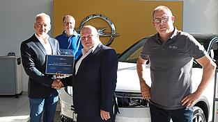 Peter Reif, Michael Klauk (von links) und Robert Kagermeier (rechts) freuen sich &uuml;ber die Auszeichnung. Ralf M&uuml;ller gratuliert. Sp&auml;ter gesellte sich auch noch Regionalleiter Opel, Dean Rusch (nicht im Bild), dazu.