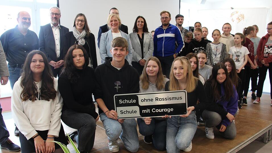 Die Sch&uuml;lersprecher Tobias Holzfurtner (v.li.) Leni Brandmann und Vanessa Rothert mit der Auszeichnung. Dahinter die Ehreng&auml;ste und Schulleiterin Ida Maria K&auml;rtner, Vertrauenslehrerin Tanja Pfeffer und Martin Birkner.