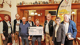 Alois Ederer (Zweiter von links) und die Mitglieder der Blaskapelle De Unsern, Wirtshauseigent&uuml;mer Ernst Aumer (Dritter von links) und Wirtin Linda Griesbeck (Mitte) haben die Spende an Christa und Engelbert Wei&szlig; (rechts) vom Projekt Theo &uuml;bergeben.
