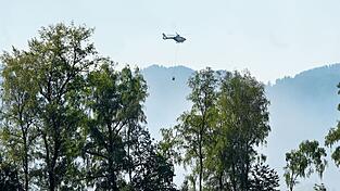 Auch mit einem Hubschrauber versuchen Einsatzkräfte die Flammen zu löschen. Auch mit einem Hubschrauber versuchen Einsatzkräfte die Flammen zu löschen.