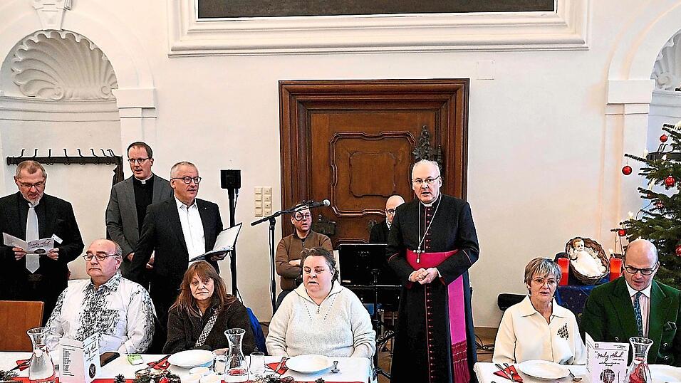 Bischof Rudolf Voderholzer sang zusammen mit F&uuml;rstin Gloria (Zweite von rechts), F&uuml;rst Albert (rechts), Caritasdirektor Michael Wei&szlig;mann (Dritter von links), Caritasvorsitzendem Michael Dre&szlig;el (Zweiter von links) und Christian Hierold, Caritas-Fachreferent f&uuml;r Menschen in besonderen Lebenslagen (links) Lieder, bevor er Essen an die G&auml;ste servierte.