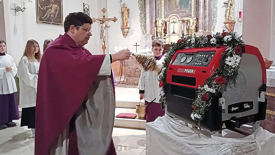 Pfarrer Emanuel Hartmann bei der Segnung der Tragkraftspritze. Zuvor hatte er das Einbringen der Wehr auch in das kirchliche Leben hervorgehoben.