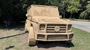 Wie ein echter SUV, der voll von Schlamm bedeckt ist steht das Kunstwerk da.
