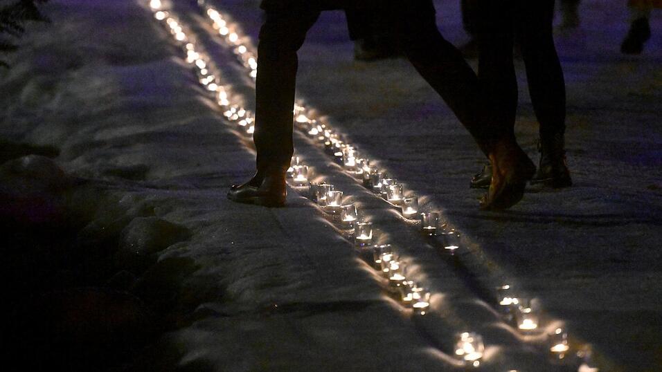 Kerzen in einer symbolischen Loipe erinnern an Laura Dahlmeier.