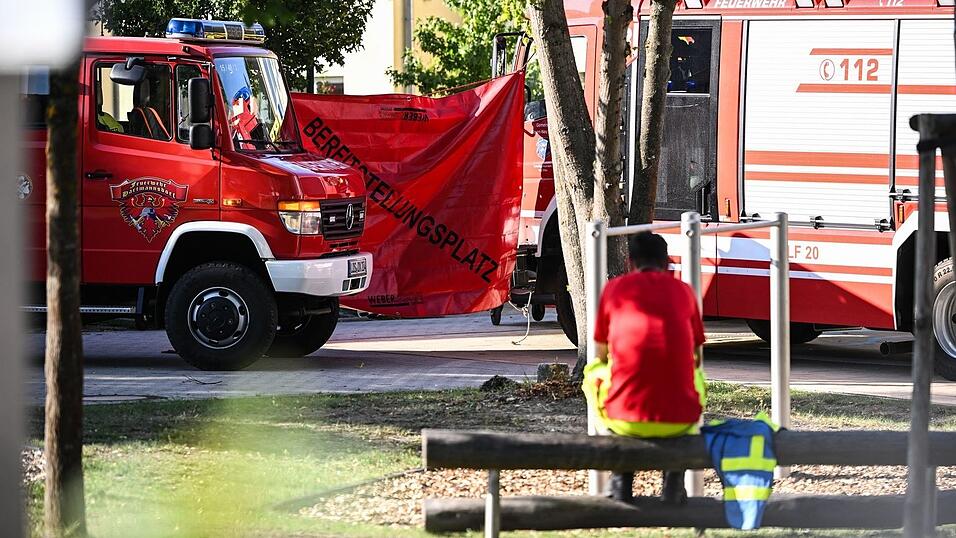 Ein Feuerwehrmann sitzt in der N&auml;he des Tatorts.