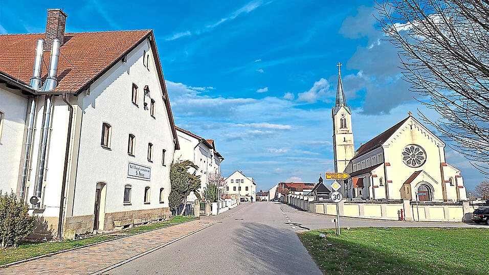 Die Ortsdurchfahrt in Otzing mit dem Evangelisationszentrum (l.) und der Kirche (r.).