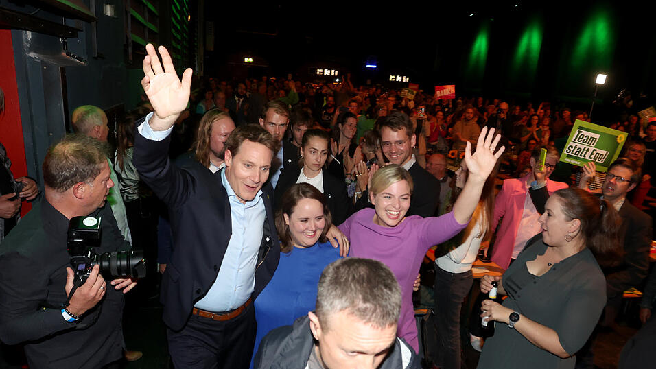 Ricarda Lang (M), die Bundesvorsitzende von Bündnis 90/Die Grünen geht mit den beiden Spitzenkandidaten der Partei, Katharina Schulze (r) und Ludwig Hartmann bei der Wahlparty zur Landtagswahl in Bayern zur Bühne.