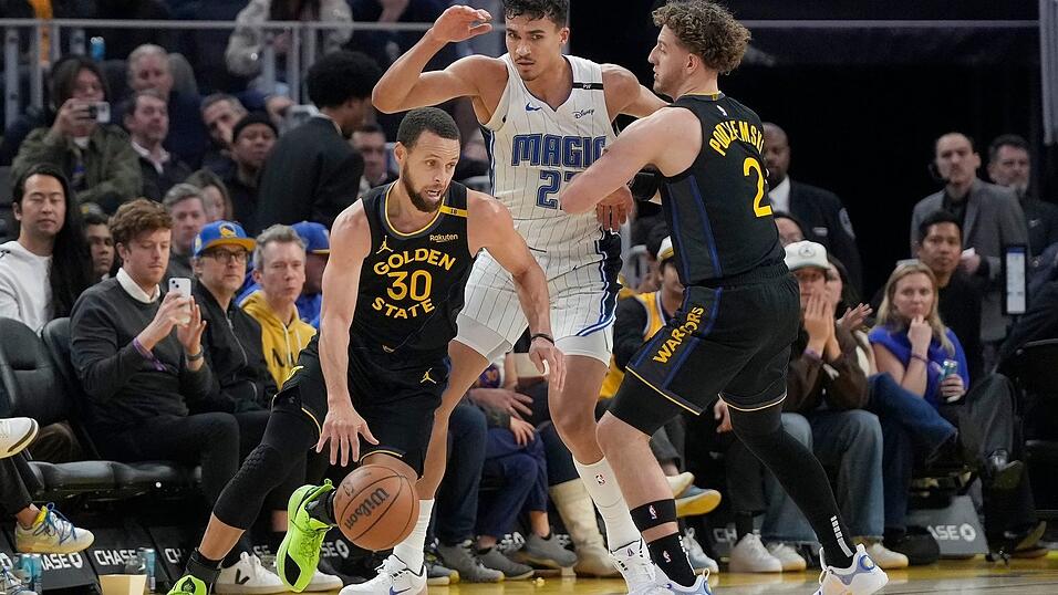 Orlandos Tristan da Silva (Mitte) sammelte gegen All-Star Stephen Curry (l.) zwei Pünktchen.