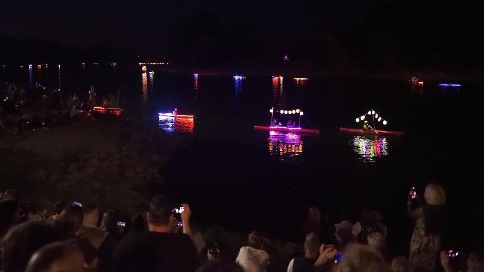 Bunt beleuchtete Boote fahren bei der Lampionfahrt über die Donau.