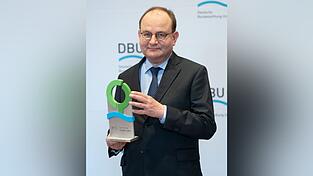 Der Preisträger des Deutschen Umweltpreises, Ottmar Edenhofer, Klima-Ökonom, Direktor des Potsdam-Instituts für Klimafolgenforschung, zeigt seine Auszeichnung.