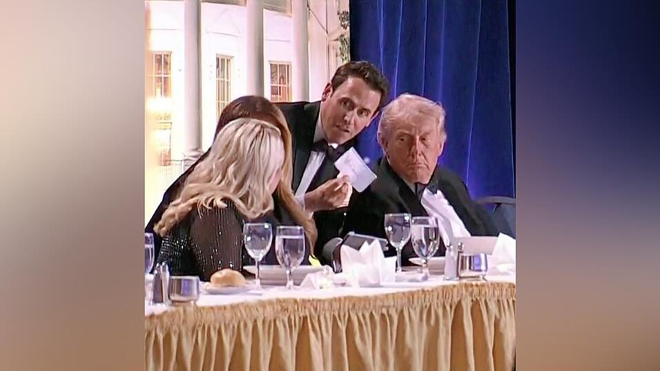 Ein Mann &uuml;berbringt Donald Trump (r.) eine Nachricht. Kurz darauf wird der Pr&auml;sident in Sicherheit gebracht.