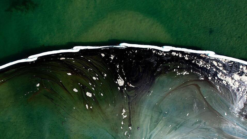 Eine Luftaufnahme zeigt schwimmende Barrieren, die nach einem Ölunfall in Huntington Beach, Kalifornien, um ein weiteres Eindringen in die Wetlands Talbert Marsh zu verhindern. Ein großer Ölaustritt vor der Küste Südkaliforniens verschmutzte beliebte Strände und tötete Wildtiere, während sich die Einsatzkräfte am Sonntag bemühten, das Öl einzudämmen, bevor es sich weiter in geschützte Feuchtgebiete ausbreiten konnte.