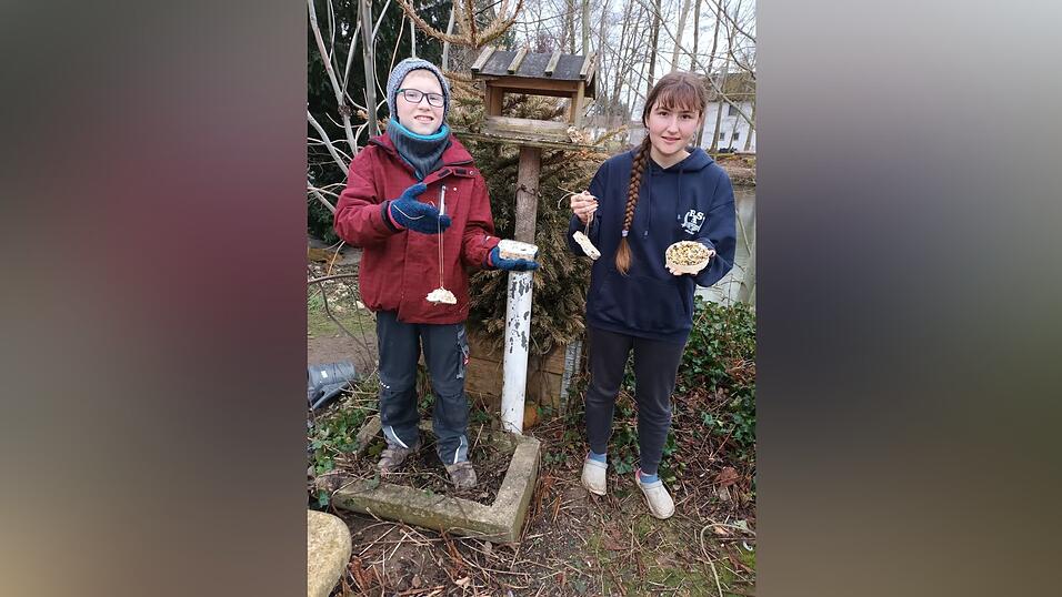 Benedikt und Milena bringen die Leckereien für die Vögel am Futterhäuschen an. Benedikt und Milena bringen die Leckereien für die Vögel am Futterhäuschen an.