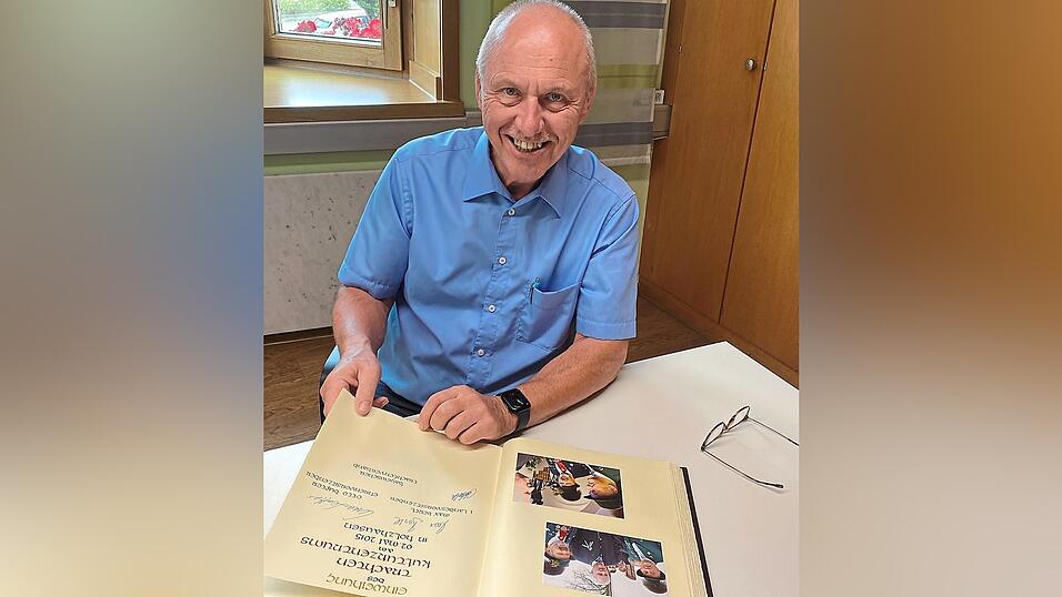 Bürgermeister Josef Reff blättert im Goldenen Buch der Marktgemeinde Geisenhausen.